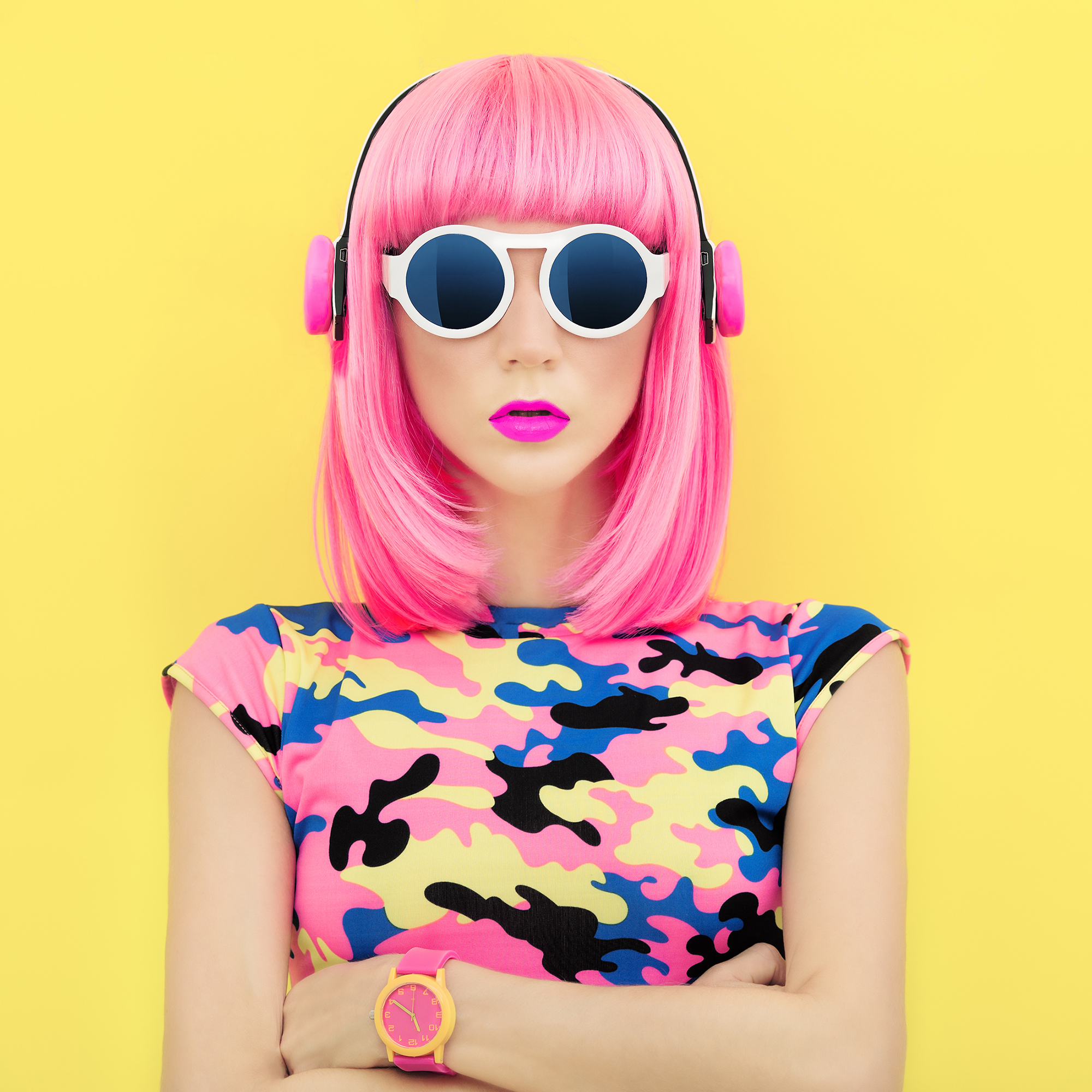 pink haired girl in a military pink top with headphones on yellow background