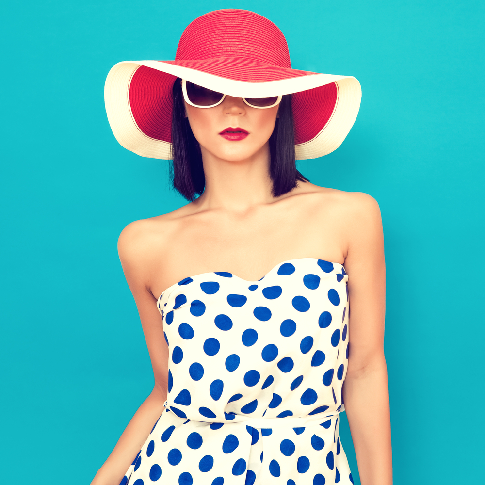 girl in red and white hat and white dress with blue dots on blue background